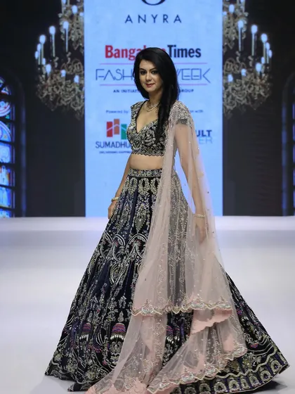 Our showstopper moment from Bangalore Times Fashion Week, worn by actress Kamana Jethmalani. This royal blue velvet lehenga features intricate hand-craftsmanship and is paired with a contrasting dusky peach dupatta for a truly unforgettable runway look.