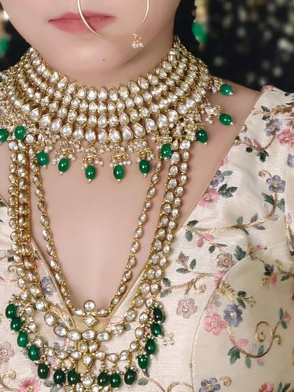 A close-up of a layered Kundan necklace with green beads. This shot shows the beautiful cascade effect of the multiple necklaces.
