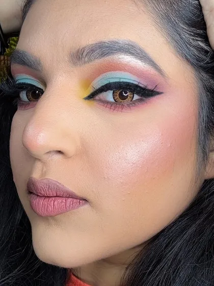 A close-up of the creative eye makeup, showing the winged liner and the blend of multiple colors.