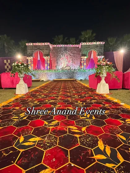 A grand stage with an intricately designed backdrop, flanked by plush pink sofas, ready for the main event.
