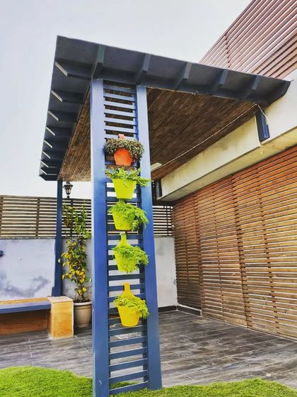 Another angle of the blue pergola, showing the contrast between the colorful planters and the dark blue structure.