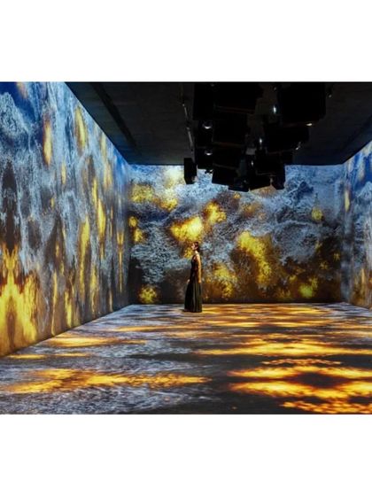 An immersive digital projection within the Aatma Manthan Museum. Here, a visitor is enveloped by visuals of fire and rock, creating a powerful, multi-sensory experience of elemental forces.