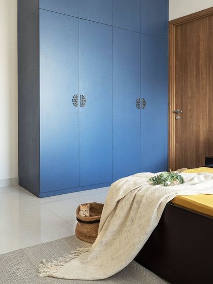 Wardrobes can be statement pieces. For this bedroom in Project 38, we chose a bold royal blue laminate and paired it with ornate oriental brass handles, transforming a simple storage unit into a major design feature that defines the room's character.
