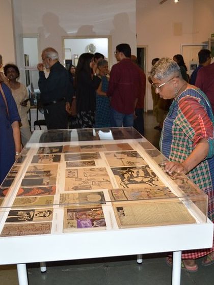 A visitor examining the archival vitrine at the 'Hand Prints' show.