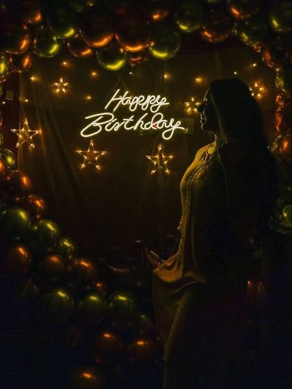 A beautiful, moody shot of a guest in front of the star-lit birthday decoration. The warm lighting is perfect for creating memorable and artistic birthday portraits.
