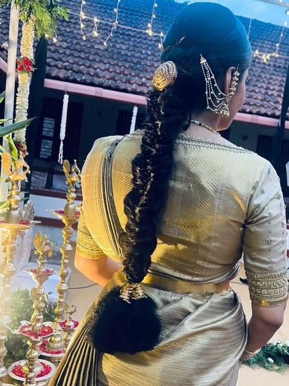 A back view of Neha's muhurtham look, showcasing her traditional hairstyle and the elegant simplicity of her gold embroidered blouse.