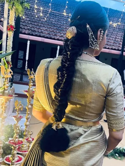 A back view of Neha's muhurtham look, showcasing her traditional hairstyle and the elegant simplicity of her gold embroidered blouse.