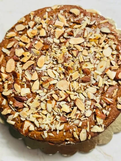This is my classic wholewheat jaggery cake, generously topped with sliced almonds for a wonderful crunch. It's a simple, wholesome tea cake that's perfect with a cup of chai.