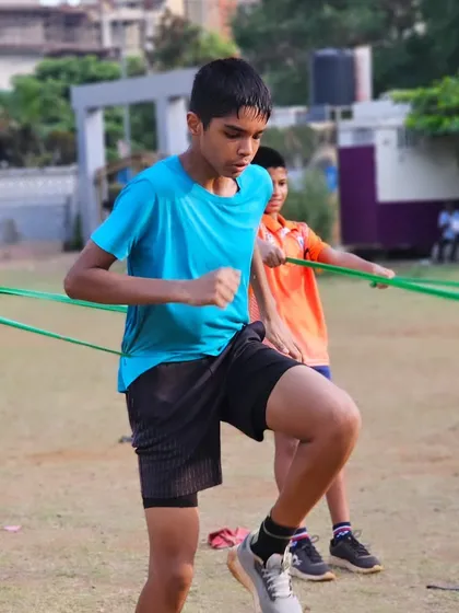 A young athlete uses resistance bands for a dynamic warm-up, activating key muscle groups before a demanding training session.