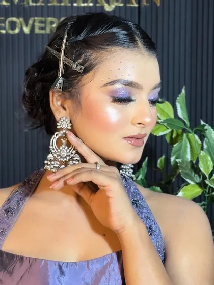 Another angle of the purple look, with the model's hand framing her face to show off the makeup.