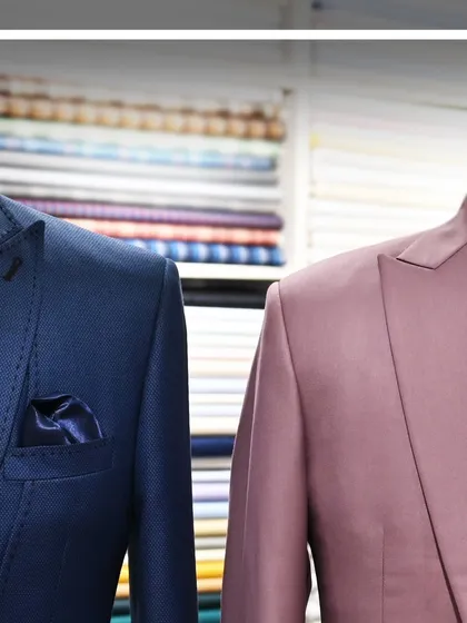 A detailed shot of the shoulders and lapels of the blue and mauve suits, emphasizing the tailoring.