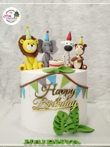 This safari party cake brings together the cutest jungle animals for a wild celebration. We topped this cake with hand-molded fondant figures of a lion, elephant, zebra, and monkey, all wearing tiny party hats.