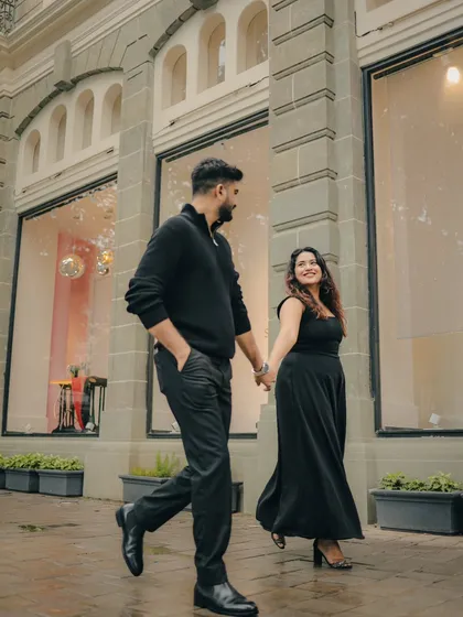 A candid shot of a couple walking hand-in-hand through the streets of Mumbai. This photo represents the modern, urban love story, capturing natural movement and emotion against the city's architecture.