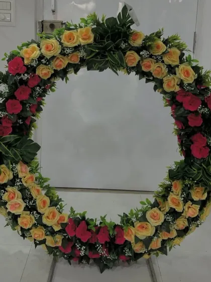 Another view of this classic red and yellow rose wreath, a versatile piece that brings color and elegance to any event.