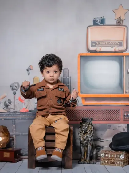 The star of the show takes his seat. This portrait captures the baby looking confident and curious, perfectly embodying the 'Chhota RJ' persona.