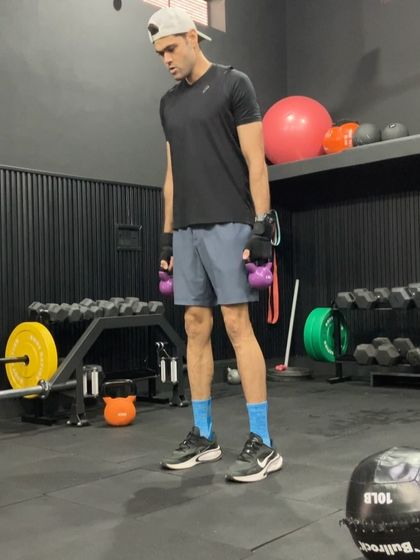 An athlete preparing for a weighted jump. Adding a light load to jumps can increase the power stimulus, but it's crucial to maintain explosive intent and proper form.