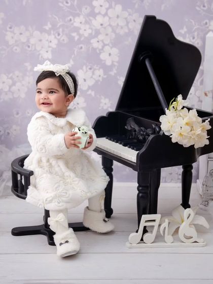 Another beautiful shot from a piano-themed milestone session, capturing the joy and innocence of being almost one.