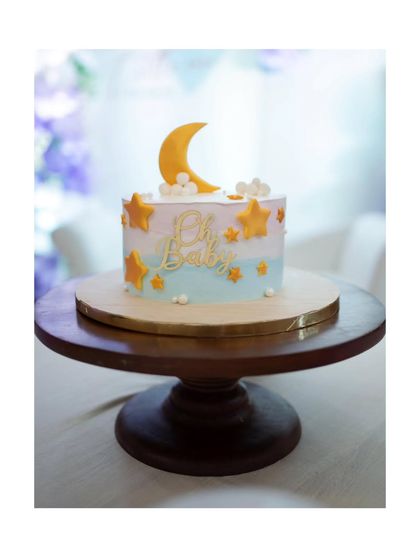 A close-up of the adorable "Oh Baby" themed cake, featuring a crescent moon and stars, perfectly matching the sweet and dreamy vibe of the baby shower.