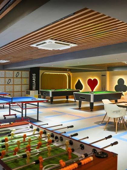 The games room at Trilogy, Ekta Tripolis, is designed for fun and social interaction. With foosball, table tennis, and pool tables, the space uses bold graphics and a dynamic layout to create a lively and engaging environment.