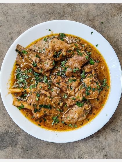 A generous serving of Bannur Mutton Saaru, garnished with plenty of fresh coriander.