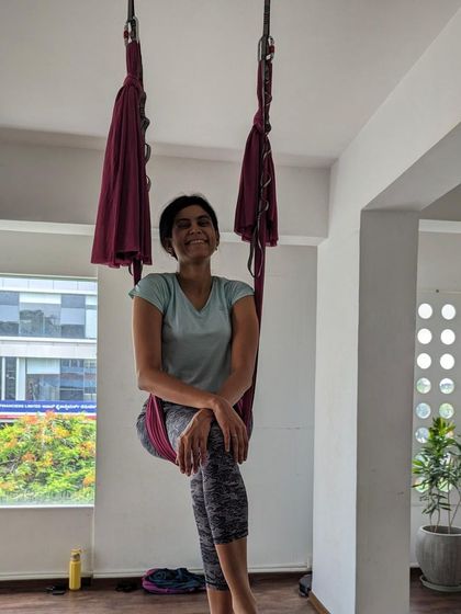 A student enjoying a quiet moment in the hammock, with the green trees of Jayanagar visible outside.