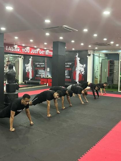 A line of students performs push-ups, building the foundational strength needed for martial arts.