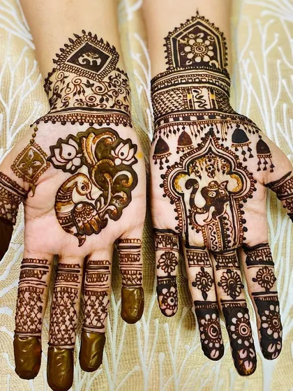 Another look at a design featuring Lord Ganesha. This style combines spiritual figures with traditional patterns like elephants, hanging bells (jhumkis), and checkerboard fills.
