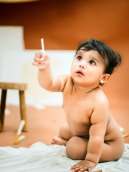 Reaching for the sky, or maybe just the ceiling. This shot captures the sweet innocence of a baby's world.