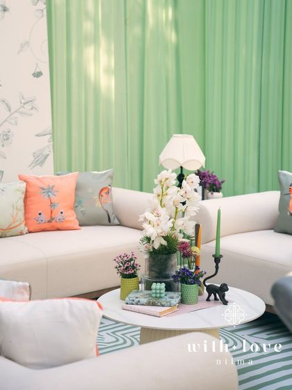 A cozy seating area in 'The Conservatory', with plush sofas and custom-printed cushions.