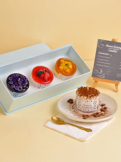 The complete Cheesecake Gift Box, featuring Tiramisu, Mango, Strawberry, and Blueberry cheesecake candles. It's the ultimate guilt-free dessert platter.