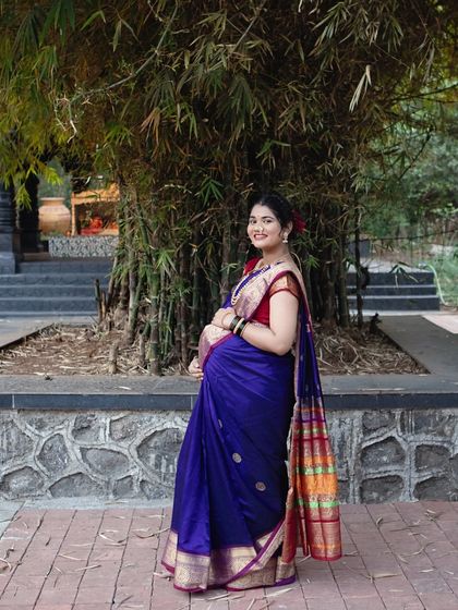 A classic portrait of the mother-to-be in her gorgeous purple saree. Her joyful expression and traditional styling make this a timeless photograph.