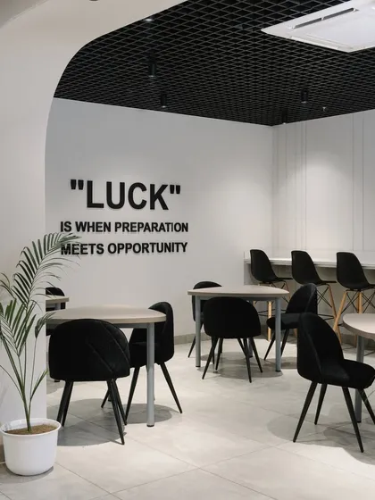 The staff cafeteria features a monochromatic black and white theme, with an inspirational quote on the wall. This space is designed for relaxation and social interaction.