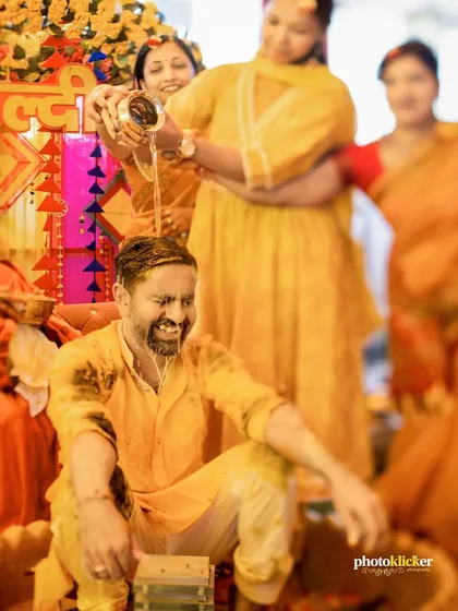 A fun-filled moment as water is poured on the groom during the haldi rituals, showcasing the playful traditions we love to document.