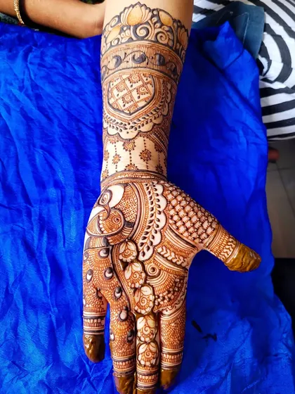 A sweet and simple floral henna piece. This design features a peacock on the palm and a heart motif on the wrist, making it a lovely choice for an engagement or party.