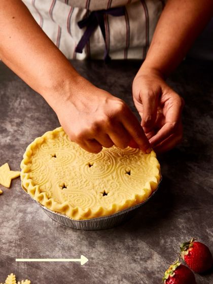 Carefully crimping the edges and adding decorative cutouts to our Strawberry Balsamic Pie before it goes into the oven.