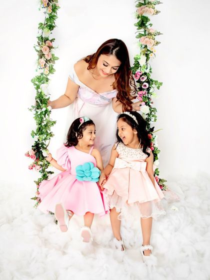 A mother watching over her two beautiful daughters on our floral swing. This photo captures the quiet, loving moments that make motherhood so special.