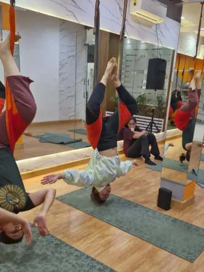 A group of flyers enjoying the benefits of a supported inversion. This pose helps lengthen the spine and release tension in the neck and shoulders. Plus, seeing your friends next to you makes it way less intimidating.