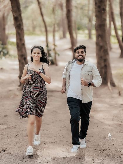 A fun, energetic shot of the couple running through a wooded path. This captures their youthful and adventurous spirit.