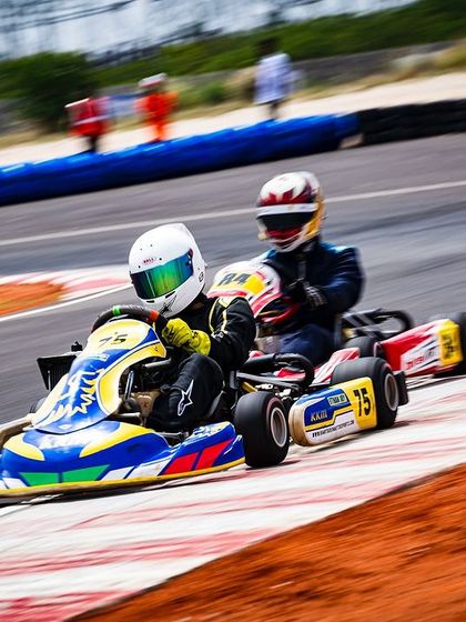 Wheel to wheel action during a heat race. A driver from our team makes a move on the inside, showcasing the close quarters racing that defines competitive karting.