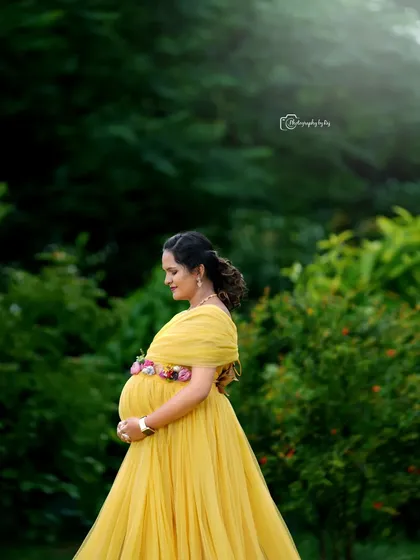 A beautiful solo portrait of a mother-to-be in a yellow gown, enjoying the tranquility of our garden.