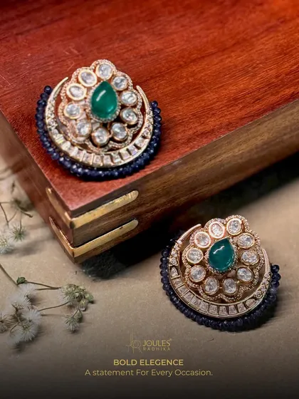 Bold elegance for every occasion. These crescent-shaped studs feature a central emerald drop surrounded by polki diamonds and a navy blue beaded edge.