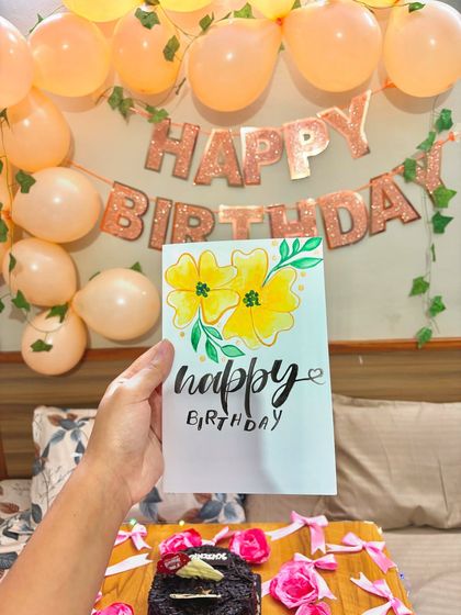 Holding up the finished birthday card against a backdrop of party decorations.