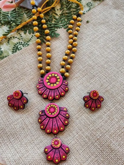 This three-layer floral pendant necklace is shown here in a lovely onion pink and red color combination. The layered design gives it depth, and it comes with cute matching studs.