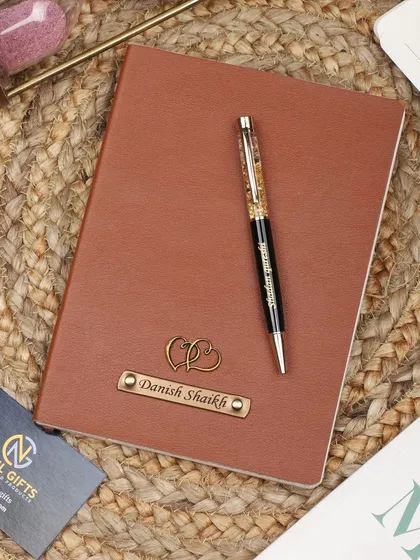 This personalized tan leather diary is customized with a double heart charm, perfect for an anniversary or a gift for a loved one.