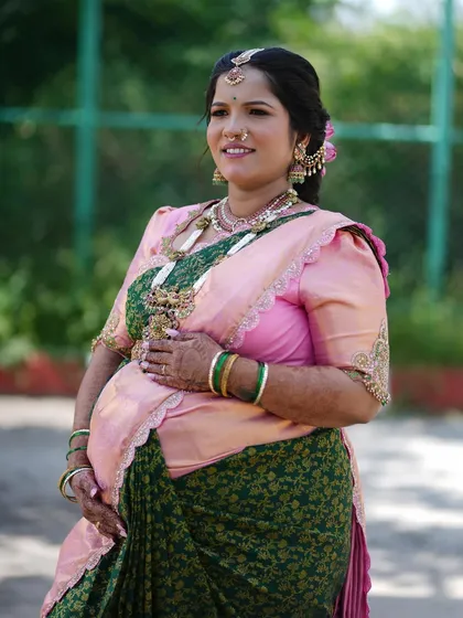 My sister-in-law Anjali's Seemantham look. It was so special to create this vibrant look for her, pairing a pink and green saree with traditional jewelry.