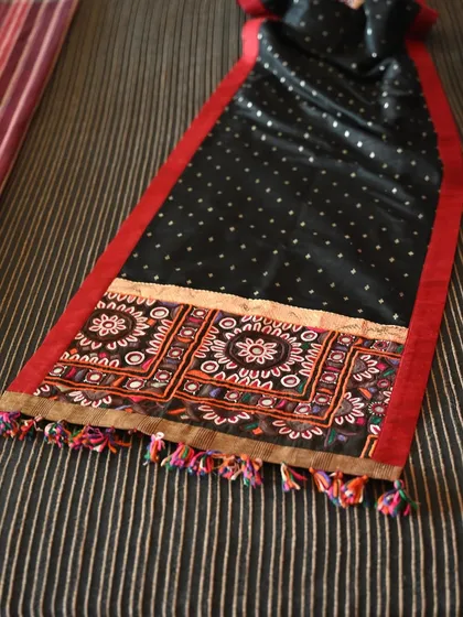 Another view of the reversible runner, highlighting its elegant drape and the vibrant colors of the tribal embroidery.