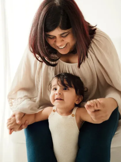 A mother and her baby share a sweet moment together. The soft lighting and gentle interaction make this a beautiful lifestyle portrait.