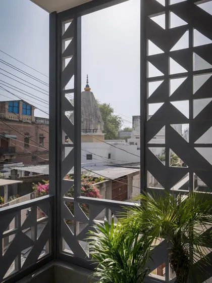 The geometric screen frames a view of a nearby temple dome. We used these urban markers as anchors, intentionally framing distant views to make the compact home feel more expansive.