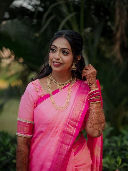 A candid shot of the bride looking away with a gentle smile. This portrait captures her elegance and the beauty of her traditional jewelry and hairstyle for the engagement.