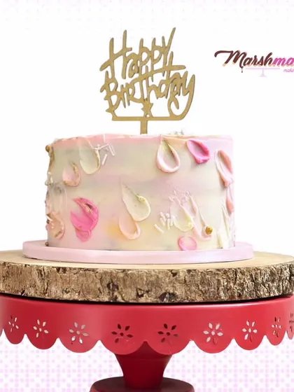 A delicious Neopolitan cake with alternate layers of chocolate, strawberry, and vanilla, decorated with a pretty, abstract petal effect.